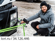 Orenburg, Russia - December, 18, 2019: A videographer fixes a video camera on a bumper of a truck, winter. Редакционное фото, фотограф Вадим Орлов / Фотобанк Лори