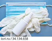 Медицинская маска, антисептик и перчатки на сером фоне. Стоковое фото, фотограф E. O. / Фотобанк Лори