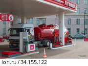 САНКТ-ПЕТЕРБУРГ, РОССИЯ - ИЮЛЬ 03, 2020: Бензовоз сливает топливо на автомобильной безнозаправочной станции. Редакционное фото, фотограф Виктор Карасев / Фотобанк Лори