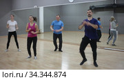Cheerful young woman enjoying active dances in modern dance studio. Стоковое видео, видеограф Яков Филимонов / Фотобанк Лори
