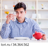 Man running out of money in restaurant and using savings from pi. Стоковое фото, фотограф Elnur / Фотобанк Лори