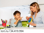 Boy with autism and teacher learn clock together. Стоковое фото, фотограф Сергей Новиков / Фотобанк Лори