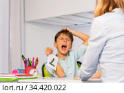 Autism boy tear hairs while learn numbers at class. Стоковое фото, фотограф Сергей Новиков / Фотобанк Лори