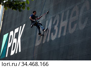 Реклама информационного холдинга "РБК" на огромном экране на фасаде здания кинотеатра Октябрь на улице Новый Арбат в городе Москве, Россия (2020 год). Редакционное фото, фотограф Николай Винокуров / Фотобанк Лори