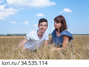 Single mother looking with love at her teen age son, people sitting on wheat field. Стоковое фото, фотограф Кекяляйнен Андрей / Фотобанк Лори