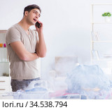 Inattentive husband burning clothing while ironing. Стоковое фото, фотограф Elnur / Фотобанк Лори
