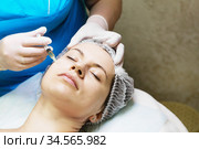 Beautician performs a needle mesotherapy treatment on a woman face. Стоковое фото, фотограф Nataliia Zhekova / Фотобанк Лори