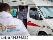 Мобильный пункт бесплатной вакцинации от гриппа в специальном автомобиле скорой помощи на Тверской улице у метро в центре города Москвы, Россия (2020 год). Редакционное фото, фотограф Николай Винокуров / Фотобанк Лори