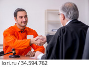 Old male judge meeting with young captive in courthouse. Стоковое фото, фотограф Elnur / Фотобанк Лори