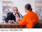 Old male judge meeting with young captive in courthouse. Стоковое фото, фотограф Elnur / Фотобанк Лори