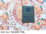 На пятитысячных российских купюрах лежит аттестат о среднем полном общем образовании. Стоковое фото, фотограф Иванов Алексей / Фотобанк Лори