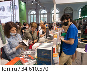 Посетители Московской международной книжной ярмарки выбирают книги (2020 год). Редакционное фото, фотограф Сайганов Александр / Фотобанк Лори