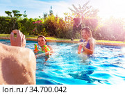 Laughing girls in swimming pool shooting water gun. Стоковое фото, фотограф Сергей Новиков / Фотобанк Лори