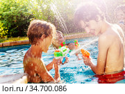 Group of kids play with water gun fight in pool. Стоковое фото, фотограф Сергей Новиков / Фотобанк Лори