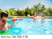 Kids play in swimming pool shooting water gun. Стоковое фото, фотограф Сергей Новиков / Фотобанк Лори