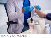 Podiatrist treating feet during procedure. Стоковое фото, фотограф Elnur / Фотобанк Лори