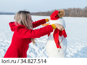 Девушка в красном пальто делает снеговика. Стоковое фото, фотограф 1Andrey Милкин / Фотобанк Лори