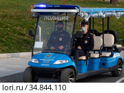 Полицейские патрулируют набережную у Северного речного вокзала на электромобиле отечественного производства от компании "Конкордия" в городе Москве, Россия (2020 год). Редакционное фото, фотограф Николай Винокуров / Фотобанк Лори