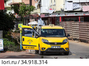 Yellow van stands on the special parking place for taxi cars. Vehicle with opened doors is waiting for passengers. Taxi service is in Alanya city. Turkey (2020 год). Редакционное фото, фотограф Кекяляйнен Андрей / Фотобанк Лори