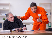 Old male judge meeting with young captive in courthouse. Стоковое фото, фотограф Elnur / Фотобанк Лори