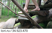 Caucasian man comes down the steps, wooden staircase of timber house, barefoot, close up view at legs, side view. Стоковое видео, видеограф Кекяляйнен Андрей / Фотобанк Лори
