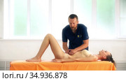 Positive male osteopath treating belly of patient. Стоковое видео, видеограф Гурьянов Андрей / Фотобанк Лори