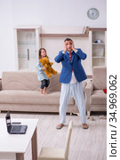 Girl bothering young father during working from house in pandemi. Стоковое фото, фотограф Elnur / Фотобанк Лори