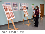 Женщина с дочерью рассматривают  детские рисунки на выставке в период эпидемии коронавируса COVID-19. Калининград (2020 год). Редакционное фото, фотограф Ирина Борсученко / Фотобанк Лори