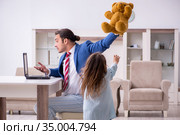 Girl bothering young father during working from house in pandemi. Стоковое фото, фотограф Elnur / Фотобанк Лори