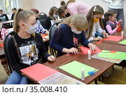 Детский мастер-класс по изготовлению самоделки из цветной бумаги. Период эпидемии коронавируса COVID-19 в России (2020 год). Редакционное фото, фотограф Ирина Борсученко / Фотобанк Лори
