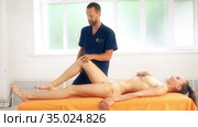 Positive male osteopath treating belly of patient. Стоковое видео, видеограф Гурьянов Андрей / Фотобанк Лори