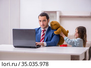 Girl bothering young father during working from house in pandemi. Стоковое фото, фотограф Elnur / Фотобанк Лори