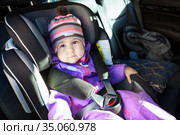 Baby sitting in a child safety seat in forward-facing position on the back car chair, adjustable headrest. Стоковое фото, фотограф Кекяляйнен Андрей / Фотобанк Лори