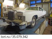 Классический американский седан Lincoln Continental Town Car  1977 модельного года в старом автосервисе (2020 год). Редакционное фото, фотограф Виктор Карасев / Фотобанк Лори