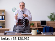 Old male employee suffering from radiculitis at workplace. Стоковое фото, фотограф Elnur / Фотобанк Лори