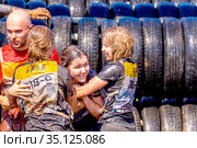Russia, Samara, June 2019: athletic youth participates in a race of heroes and overcomes obstacles car tires on a summer day in the village of Roshchinsky . Text in Russian: race of heroes, platoon. Редакционное фото, фотограф Акиньшин Владимир / Фотобанк Лори