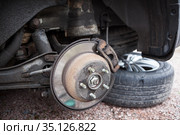 Old steel ventilated brake disk with rusty support brake pads are ready for removing, a rear wheel. Стоковое фото, фотограф Кекяляйнен Андрей / Фотобанк Лори