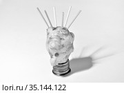 Coronavirus symbol of jerusalem artichoke and toothpicks on a pedestal of coins, on a white background. Black and white image. Стоковое фото, фотограф Владимир Литвинов / Фотобанк Лори