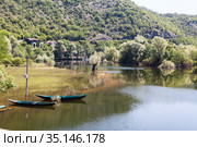 Fishing boats moored on overflowed bank of the Rijeka Crnojevica town. It is near the coast of Skadar lake. The Balkan Peninsula, Montenegro (2016 год). Стоковое фото, фотограф Кекяляйнен Андрей / Фотобанк Лори