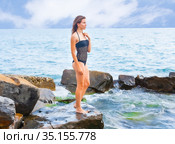 The girl stands on the beach on a rock and looks into the distance. Стоковое фото, фотограф Владимир Ушаров / Фотобанк Лори