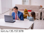 Girl bothering young father during working from house in pandemi. Стоковое фото, фотограф Elnur / Фотобанк Лори