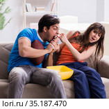 Man watching americal football with his wife. Стоковое фото, фотограф Elnur / Фотобанк Лори
