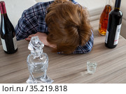 woman surrounded by bottles of alcohol - concept of female alcoholism. Стоковое фото, фотограф Володина Ольга / Фотобанк Лори