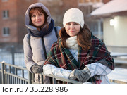 Happy positive two stylish girls standing on street in city. Closeup portrait funny joyful attractive young women dressing winter clothing. Стоковое фото, фотограф Кекяляйнен Андрей / Фотобанк Лори
