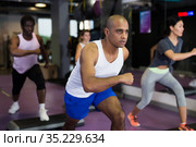 Group of people working out with steppers in fitness center. Стоковое фото, фотограф Яков Филимонов / Фотобанк Лори