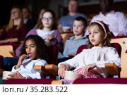 Preteen girl with mulatta mate watching movie in cinema. Стоковое фото, фотограф Яков Филимонов / Фотобанк Лори