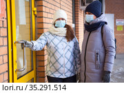 Female couple opening the door of small store for entering inside, Caucasian women wearing face mask for protect from coronavirus infection. Стоковое фото, фотограф Кекяляйнен Андрей / Фотобанк Лори