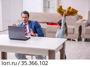 Girl bothering young father during working from house in pandemi. Стоковое фото, фотограф Elnur / Фотобанк Лори