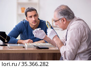 Young man visiting old male jeweler. Стоковое фото, фотограф Elnur / Фотобанк Лори