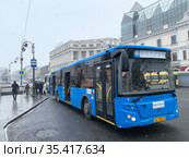 Владивосток. Автобус 31 маршрута отъезжает от остановки общественного транспорта в снегопад ранней весной (2021 год). Редакционное фото, фотограф Овчинникова Ирина / Фотобанк Лори
